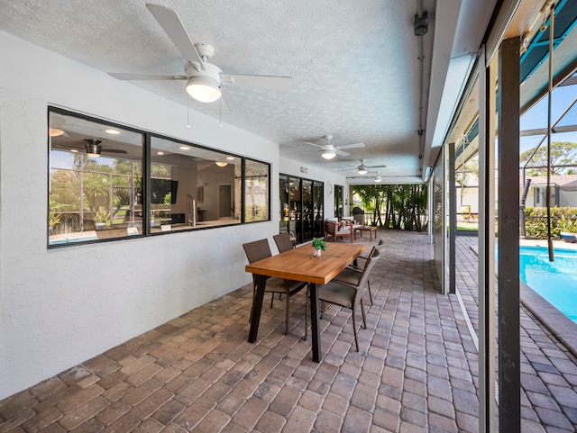 sunroom featuring ceiling fan