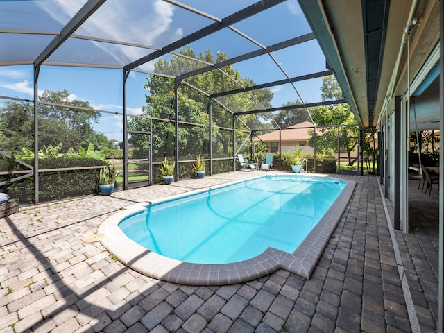 view of swimming pool featuring a patio area and glass enclosure