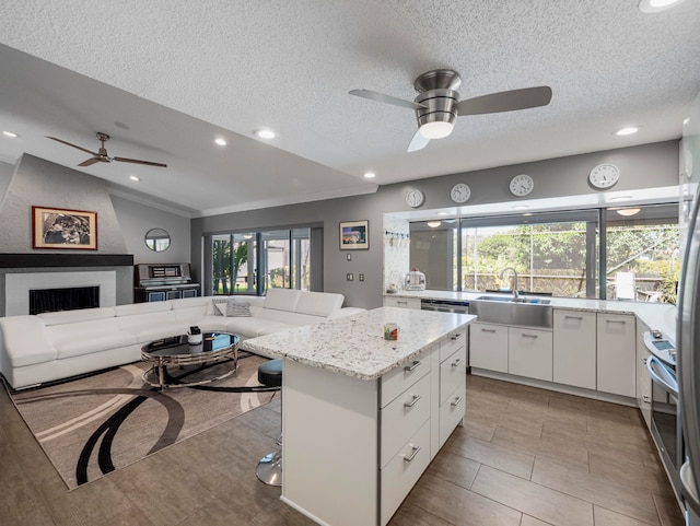 kitchen with sink, ceiling fan, white cabinets, and vaulted ceiling