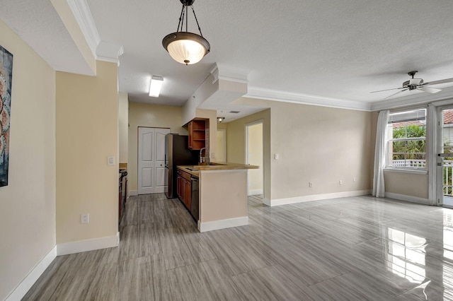 kitchen with ceiling fan, decorative light fixtures, a textured ceiling, and ornamental molding