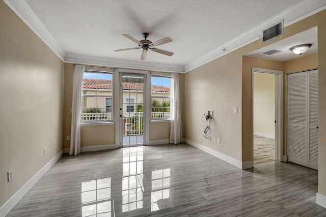 tiled empty room featuring a textured ceiling, ceiling fan, and ornamental molding