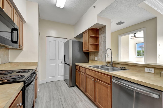 kitchen with appliances with stainless steel finishes, sink, a textured ceiling, ceiling fan, and light tile patterned flooring