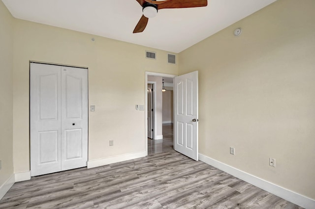 unfurnished bedroom featuring light hardwood / wood-style flooring, ceiling fan, and a closet