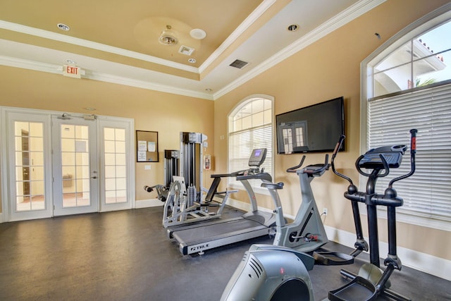 workout area with crown molding, french doors, and a tray ceiling