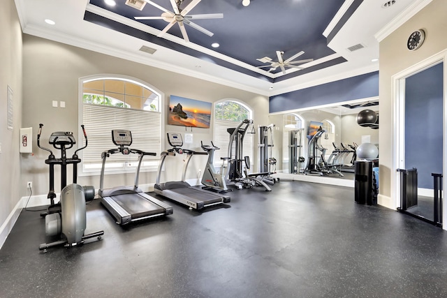 gym featuring ceiling fan, a raised ceiling, and crown molding