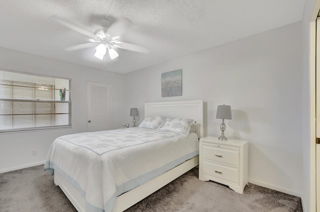 bedroom with a textured ceiling, light carpet, ceiling fan, and a closet