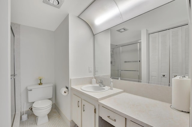 full bathroom with a closet, toilet, a stall shower, vanity, and tile patterned floors