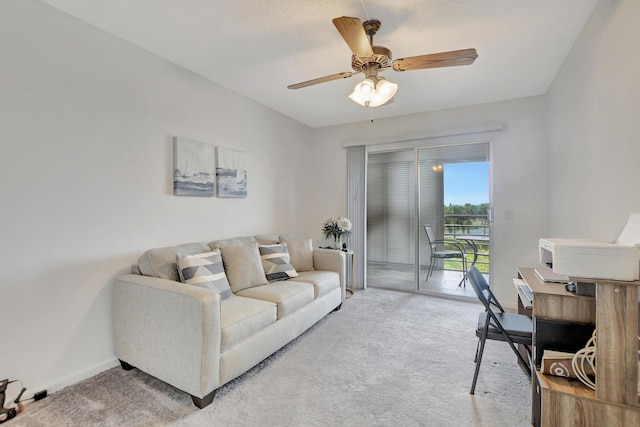 living area featuring baseboards, a ceiling fan, and light colored carpet