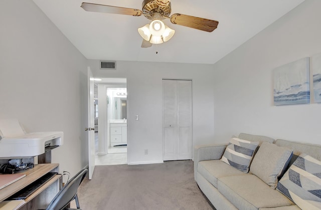 living room with a ceiling fan, visible vents, and baseboards