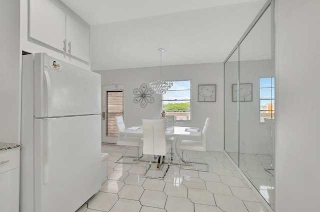 unfurnished dining area featuring light tile patterned floors and a chandelier