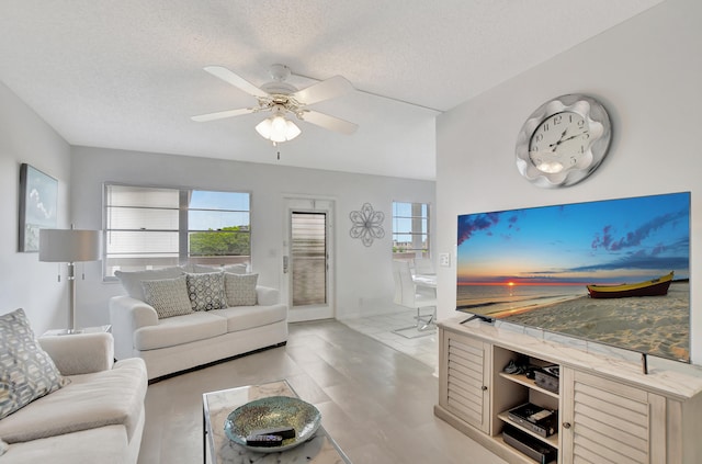 tiled living room featuring a textured ceiling and ceiling fan