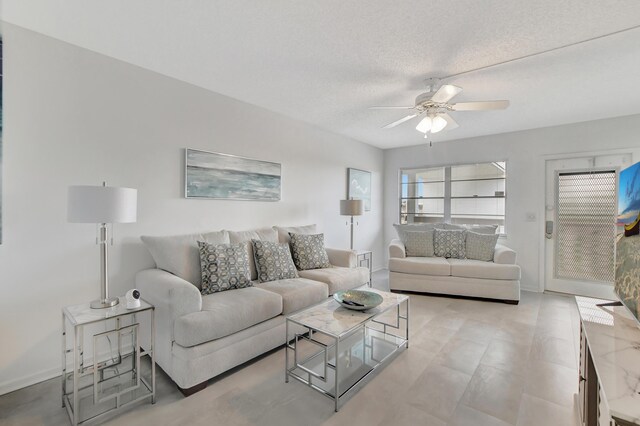 living room featuring a textured ceiling, light tile patterned floors, and ceiling fan