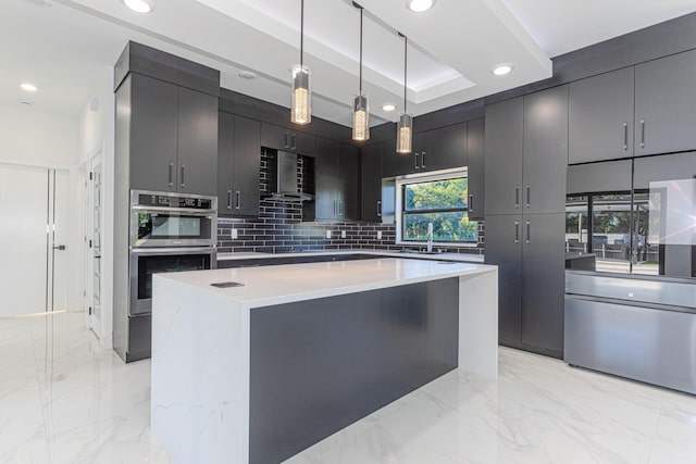 kitchen with wall chimney exhaust hood, a center island, decorative light fixtures, marble finish floor, and light countertops