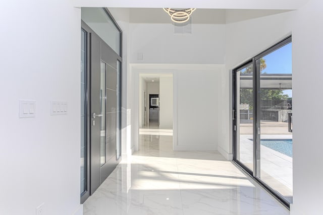 hall with marble finish floor and baseboards