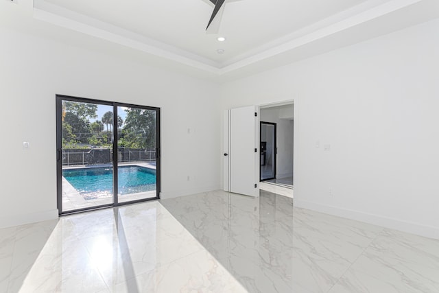 unfurnished room featuring marble finish floor, baseboards, a raised ceiling, and recessed lighting