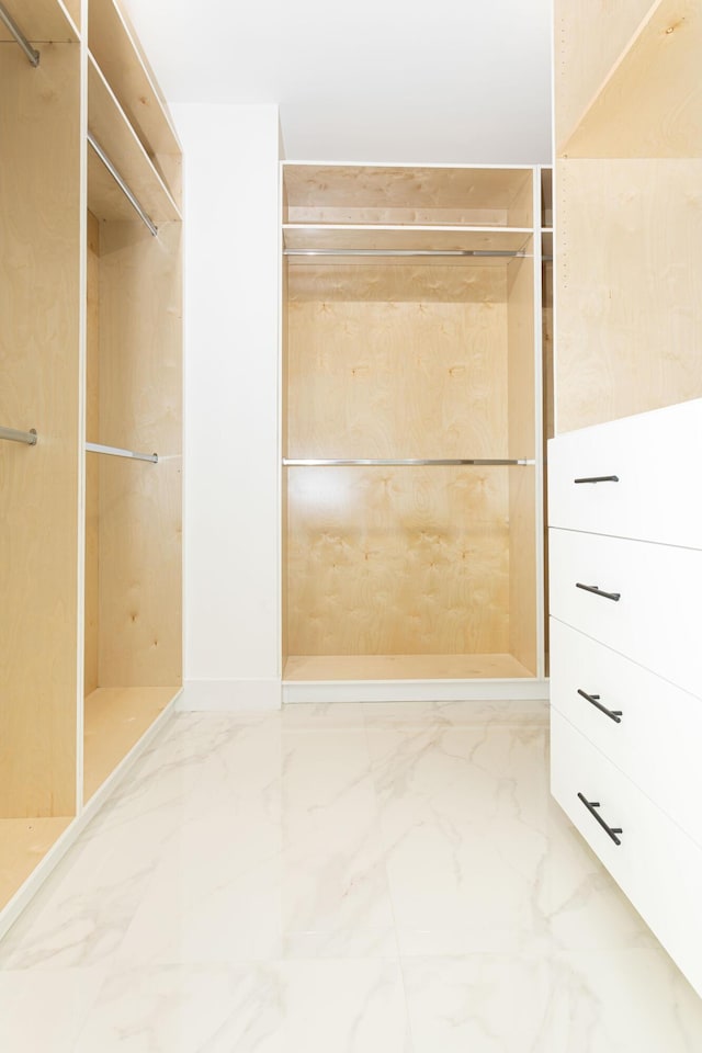 walk in closet with marble finish floor