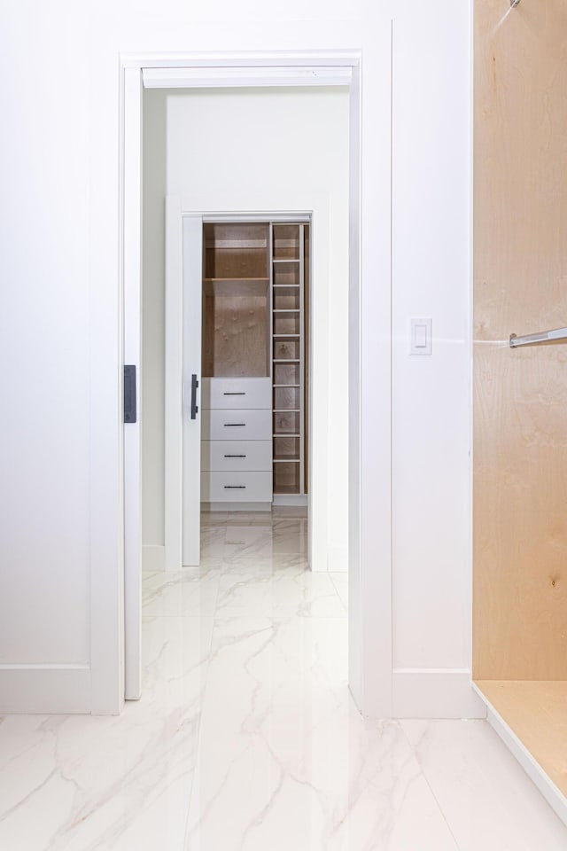 hall featuring marble finish floor and baseboards