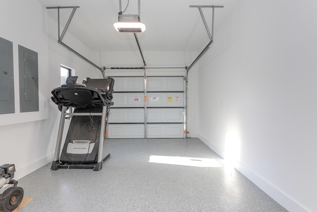 garage featuring a garage door opener, electric panel, and baseboards