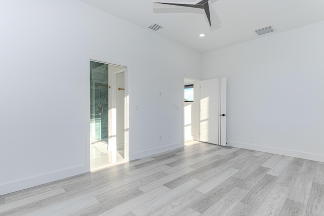 empty room featuring ceiling fan, light wood-style flooring, and visible vents