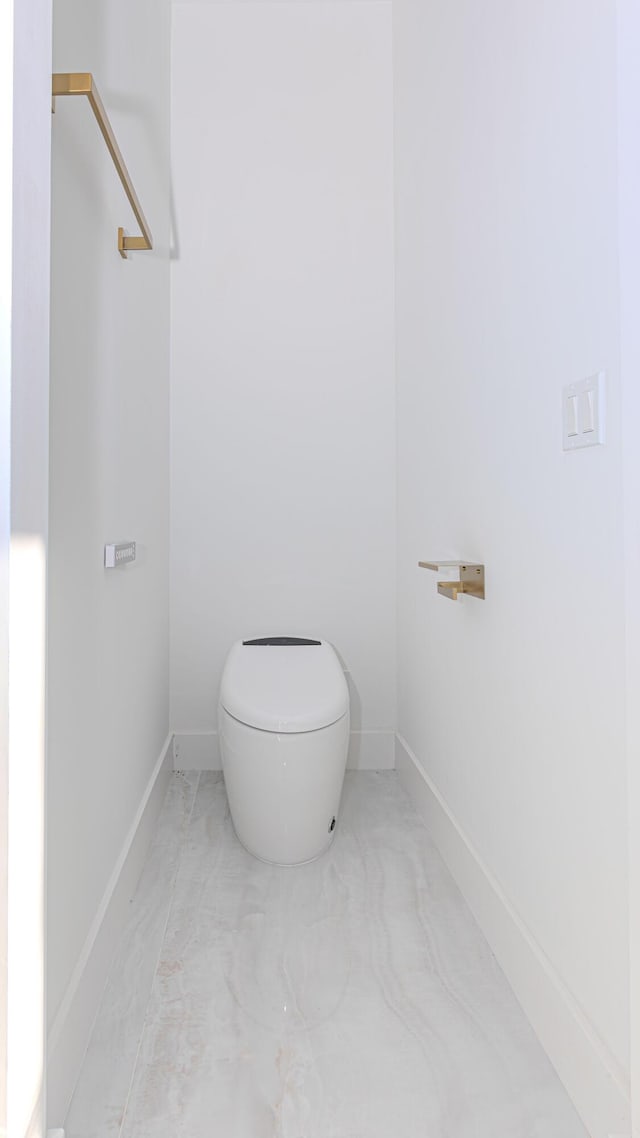 bathroom with baseboards and toilet