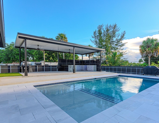 view of pool featuring a patio area, fence, a fenced in pool, and area for grilling