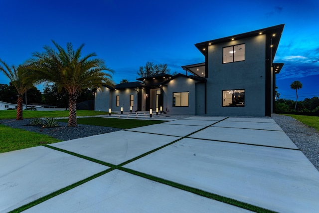 view of front of house featuring a patio, a front yard, and stucco siding