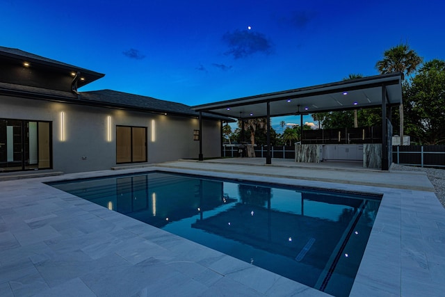 pool at dusk with fence, a fenced in pool, and a patio