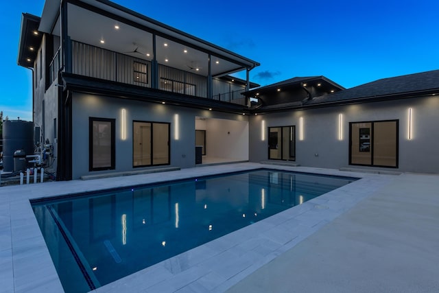 pool with ceiling fan and a patio area