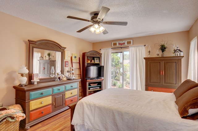 bedroom featuring light hardwood / wood-style flooring, a textured ceiling, and ceiling fan