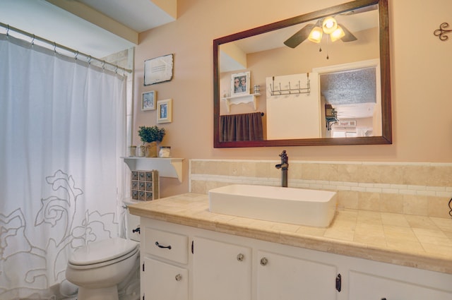 bathroom with toilet, vanity, and ceiling fan