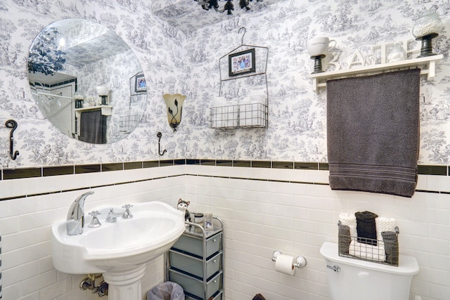 bathroom featuring sink, tile walls, and toilet