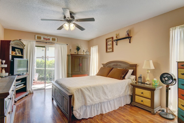 bedroom with access to exterior, ceiling fan, a textured ceiling, and hardwood / wood-style flooring