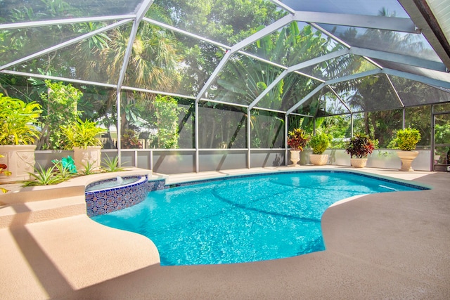 view of pool featuring an in ground hot tub, a patio area, and glass enclosure