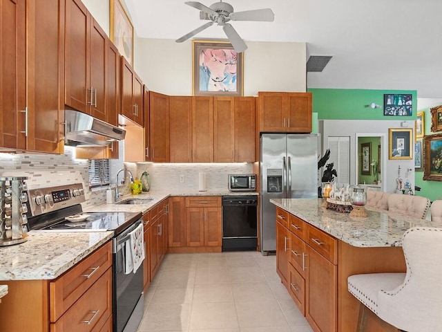 kitchen with a breakfast bar, backsplash, ceiling fan, stainless steel appliances, and sink