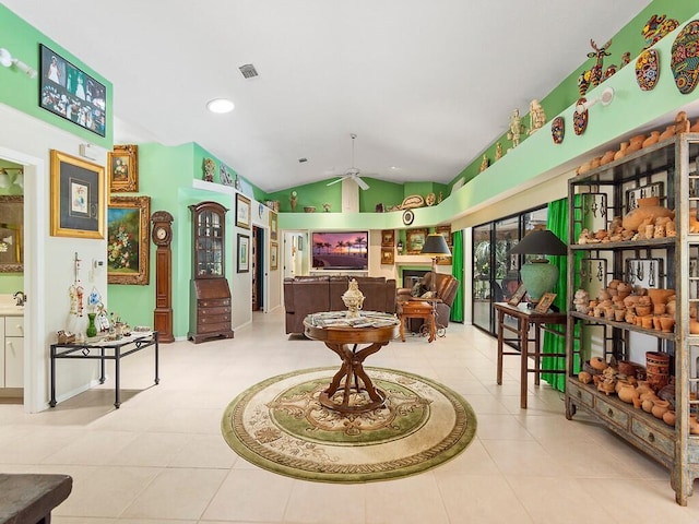 sitting room with lofted ceiling, light tile patterned floors, and ceiling fan