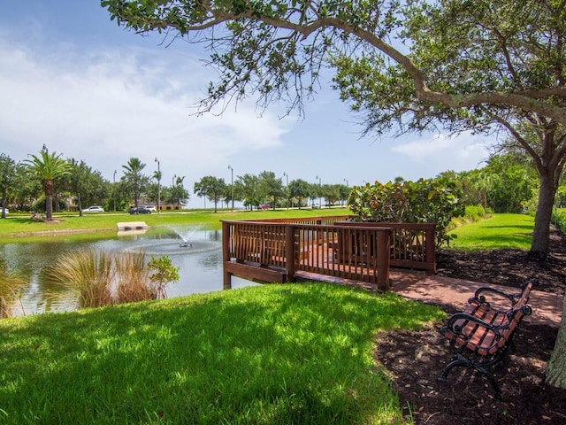 view of dock with a water view and a lawn