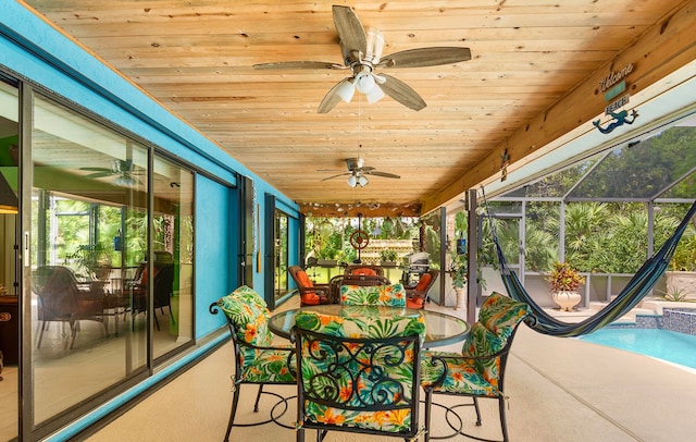 sunroom featuring wooden ceiling, ceiling fan, and a healthy amount of sunlight