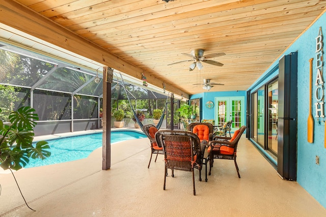 view of swimming pool with a lanai, a patio, ceiling fan, and french doors