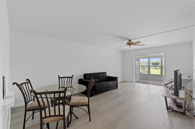 dining space with baseboards, light wood-style floors, and ceiling fan