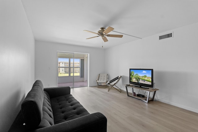 living area featuring visible vents, baseboards, wood finished floors, and a ceiling fan