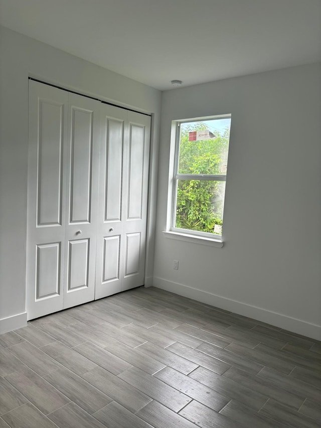 unfurnished bedroom featuring a closet and hardwood / wood-style flooring