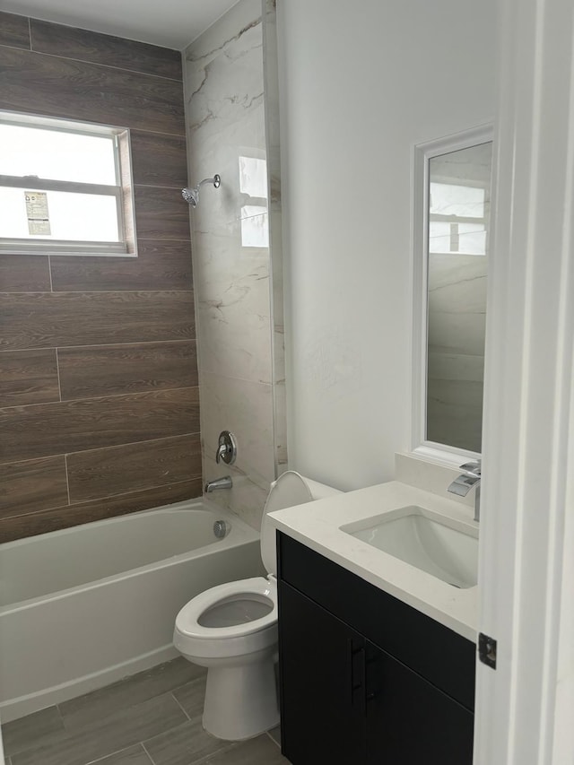 full bathroom featuring toilet, tiled shower / bath combo, and vanity