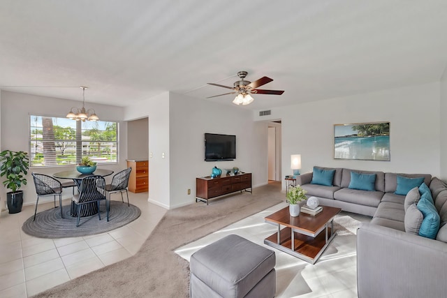 living room with light tile patterned floors and ceiling fan with notable chandelier