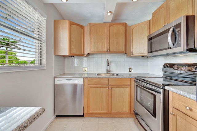 kitchen featuring appliances with stainless steel finishes, backsplash, light brown cabinetry, sink, and light tile patterned floors