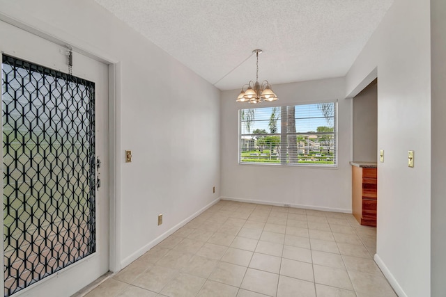 interior space with light tile patterned floors, a textured ceiling, and a notable chandelier