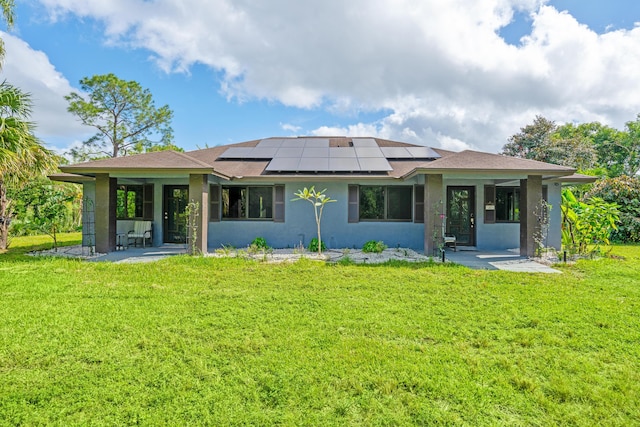 back of house featuring solar panels, a patio, and a yard