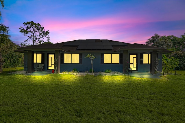 prairie-style house featuring solar panels, a yard, and a patio area