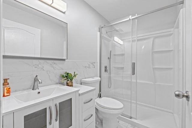 bathroom featuring toilet, an enclosed shower, and vanity