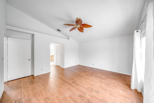 unfurnished bedroom with vaulted ceiling, a textured ceiling, ceiling fan, and light hardwood / wood-style floors