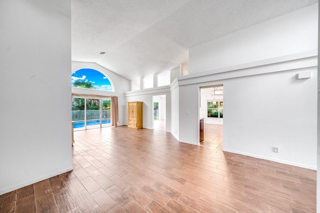 unfurnished living room featuring high vaulted ceiling